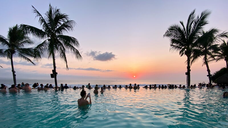 Atardecer en Bali sobre el océano con cielo naranja y rosa, reflejando la tranquilidad de la isla, paisaje tropical y destino turístico paradisíaco en Indonesia