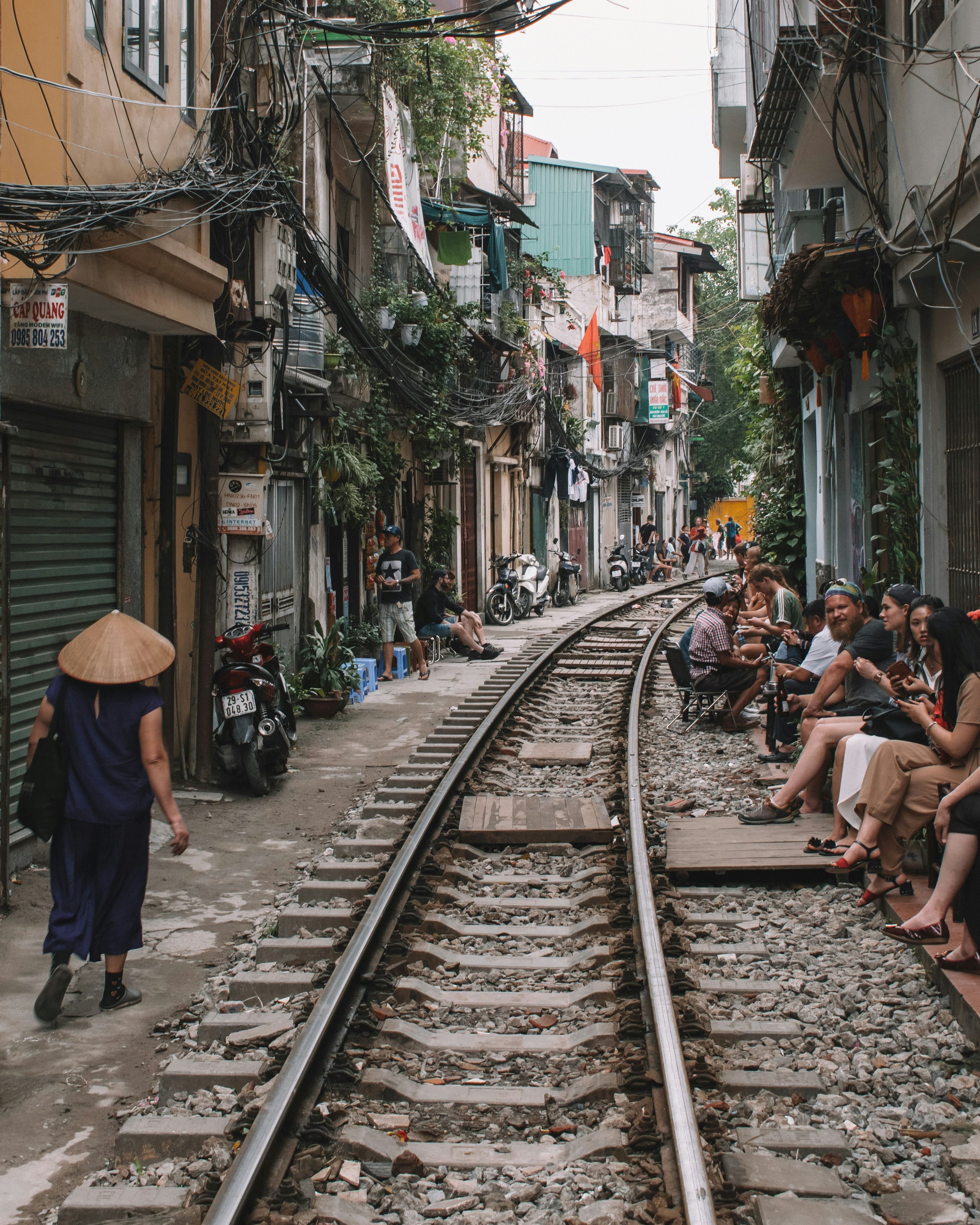 Tren de Vietnam pasando entre casas y mercadillos, mostrando la vida cotidiana y la cultura local a lo largo de las vías