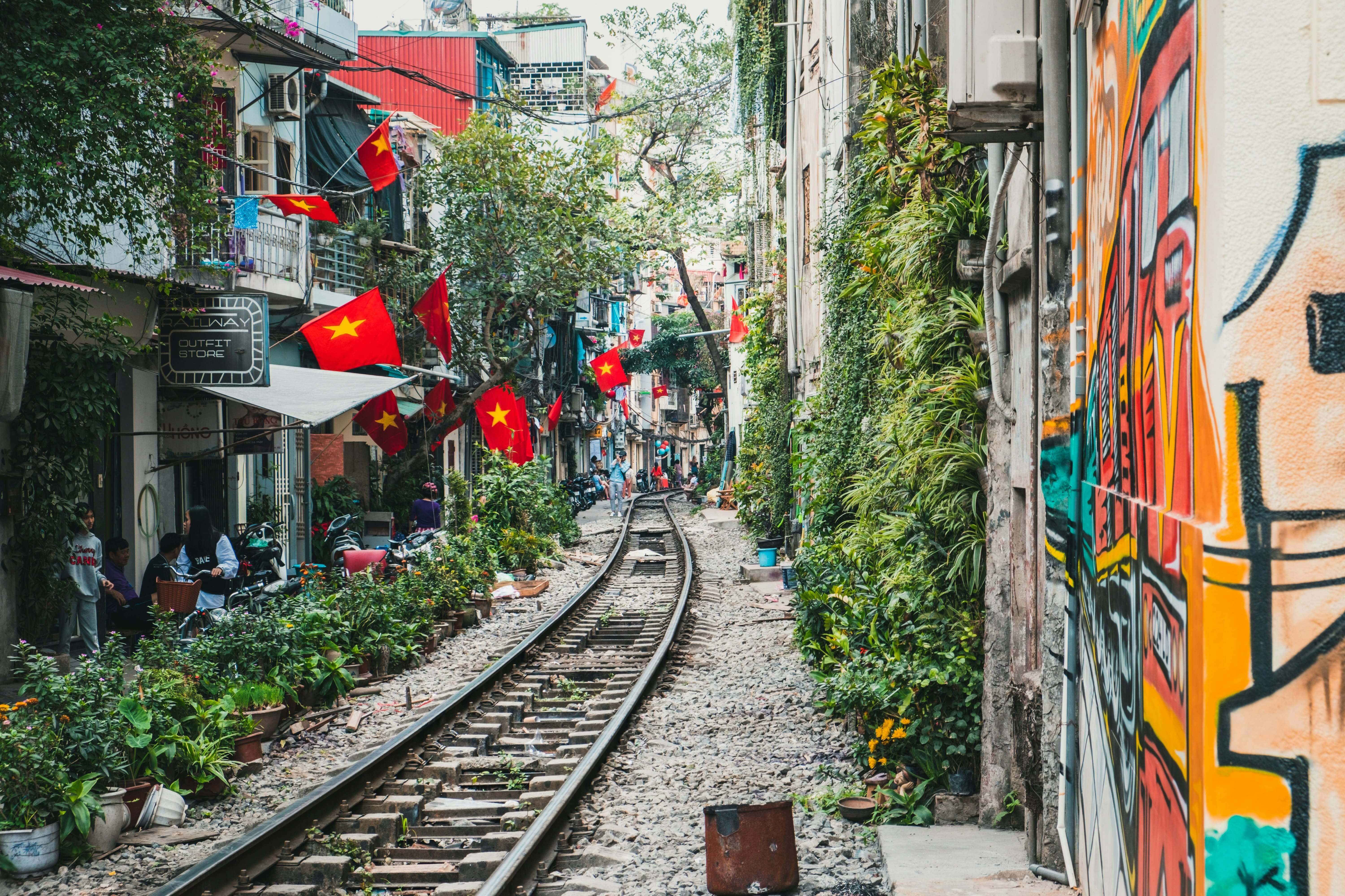 Vía de tren en Vietnam pasando junto a viviendas y mercadillos locales, escena urbana típica y auténtica del país, destino cultural del Sudeste Asiático