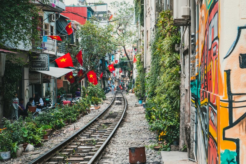 Vía de tren en Vietnam pasando junto a viviendas y mercadillos locales, escena urbana típica y auténtica del país, destino cultural del Sudeste Asiático